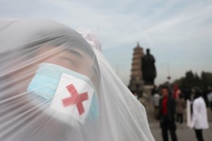 College students wearing masks pose with a plastic bag during a performance art to raise awareness of air pollution on December 5, 2013 in Xi an, China [Getty Images]