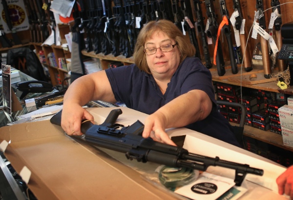 Cindy Sparr boxes up an AK-47 style rifle after selling it at Freddie Bear Sports sporting goods store on December 17, 2012 in Tinley Park, Illinois [Getty Images]