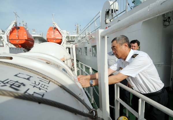 A maritime personnel checks the life rafts aboard passenger ship "Wuzhishan" at Xiuying port in Haikou, capital of south China's Hainan Province, May 18, 2014. "Wuzhishan" left for Vietnam from Xiuying port on Sunday. China began on Sunday to send five ships to evacuate Chinese nationals caught in a deadly anti-China violence in Vietnam [Xinhua]