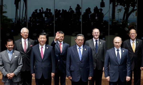 Photographers are reflected on the glass, background, as leaders of the Asia-Pacific region stand for a group photo session during the Asia-Pacific Economic Cooperation (APEC) forum in Bali, Indonesia, Tuesday, Oct. 8, 2013. They are, front left to right, Brunei Sultan Hassanal Bolkiah Chinese President Xi Jinping, Indonesian President Susilo Bambang Yudhoyono, Russian President Vladimir Putin, and back left to right, Malaysian Prime Minister Najib Razak, Mexican President Enrique Pena Nieto, New Zealand Prime Minister John Key and Philippine President Benigno Aquino III. Kerry and Rivas were filling in for their respective country leaders [AP]