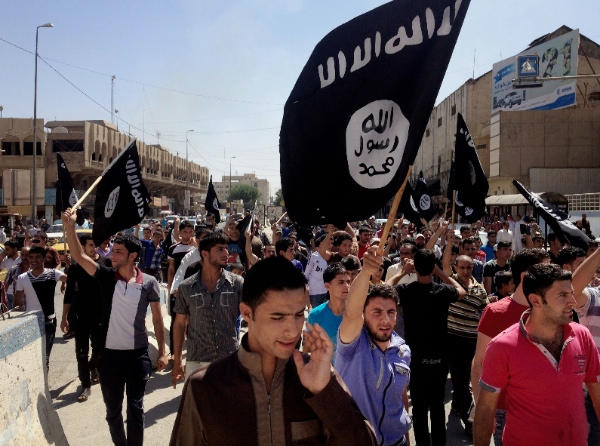 In this Monday, June 16, 2014 file photo, Demonstrators chant pro-al-Qaida-inspired Islamic State of Iraq and the Levant (ISIL) as they carry al-Qaida flags in front of the provincial government headquarters in Mosul, 225 miles (360 kilometers) northwest of Baghdad, Iraq [AP]