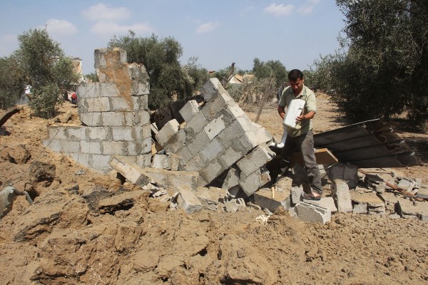 A Palestinian inspects a damaged chicken coop after an Israeli air strike in the southern Gaza Strip city of Khan Younis on July 6, 2014 [Xinhua]