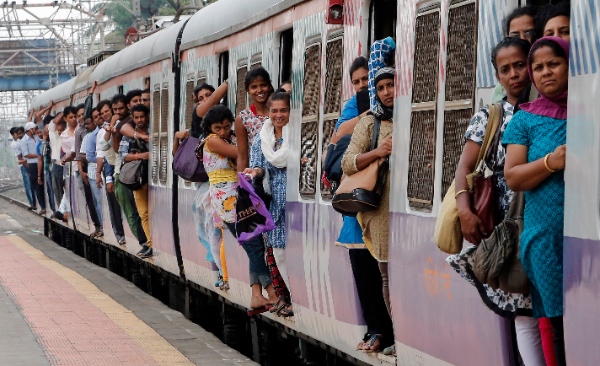  Commuters hang by doors of a crowded local train in Mumbai, India, Tuesday, July 8, 2014 [AP]