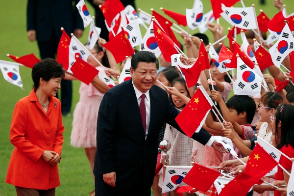 Chinese President Xi Jinping, right, and his South Korean counterpart Park Geun-hye, left, greet children during a welcome ceremony at the Presidential Blue House in Seoul, South Korea, Thursday, July 3, 2014 [AP]