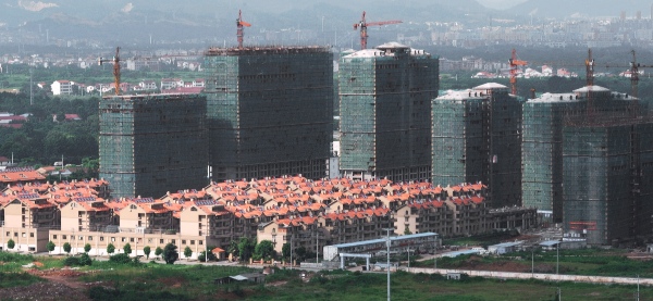 Photo taken on July 17, 2014 shows the commercial residential building under construction in Jinhua City, east China's Zhejiang Province. The sale volume of the commercial housing in the province from January to July in 2014 is 213.1 billion yuan (34.5 billion US dollars), down by 27.1% compared with the same period of last year [Xinhua]
