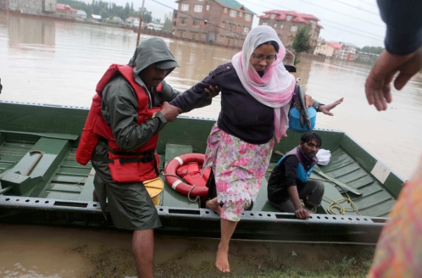  An Indian army trooper helps a woman to evacuate from flooded area in outskirts of Srinagar, summer capital of India's Jammu and Kashmir, Sept. 6, 2014