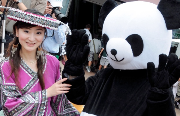 A girl in Chinese costumes poses with a mascot panda in Auckland during a China festival in New Zealand [Xinhua] 