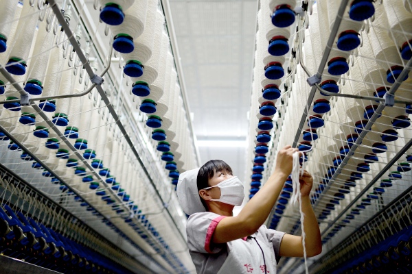  A woman works at a textile factory in Tai'an City, east China's Shandong Province, Oct. 18, 2014 [Xinhua]