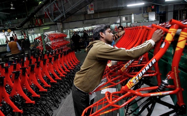 A Worker pastes stickers on bicycle parts at a factory at Ludhina in Indian state of Punjab, Feb. 1, 2014 [Xinhua]