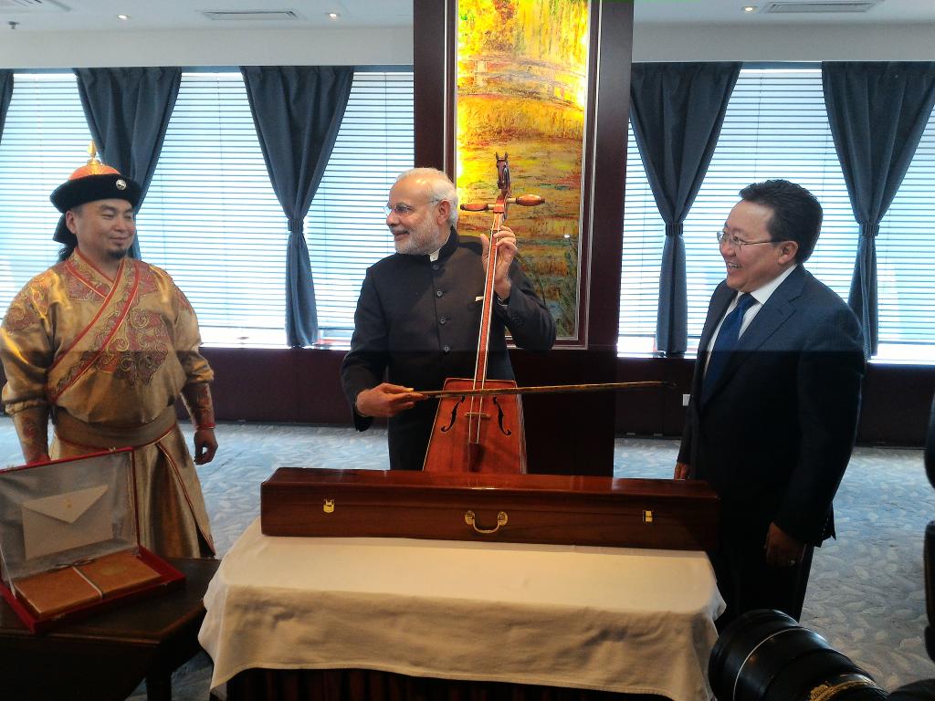 Indian Prime Minister Narendra Modi (center) tries his hand at the 'morin khuur', a traditional Mongolian bowed stringed instrument as President of Mongolia Tsakhiagiin Elbegdorj looks on [Image: MEA, India]