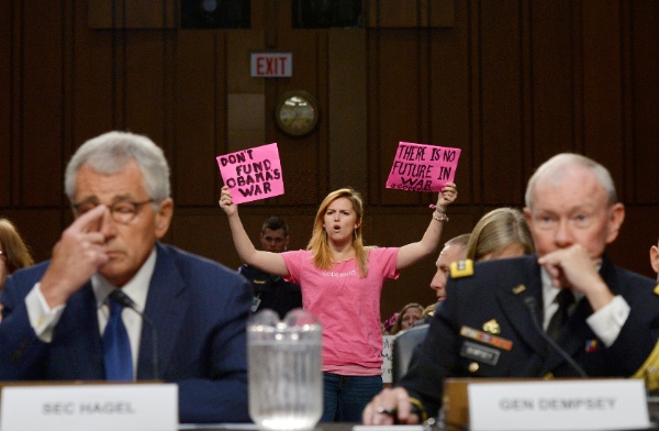 Anti-war activists protest as U.S. Defense Secretary Chuck Hagel (L) and Chairman of the Joint Chiefs of Staff General Martin Dempsey (R) testify before the Senate Armed Services Committee on Capitol Hill in Washington, D.C., the United States, Sept. 16, 2014 [Xinhua]