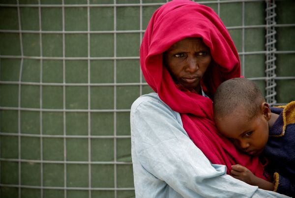 File Photo: A Somali woman holds her malnourished child [Xinhua]