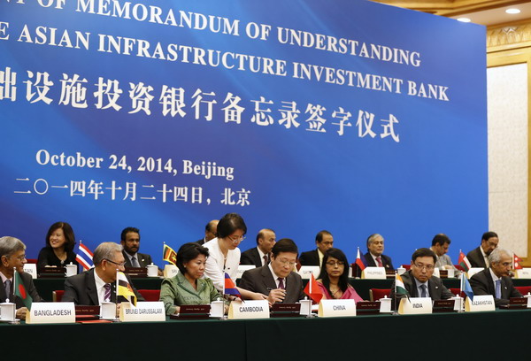 China's Finance Minister Lou Jiwei (C) signs a document, with the guests of the signing ceremony of the Asian Infrastructure Investment Bank at the Great Hall of the People in Beijing October 24, 2014 [Xinhua]