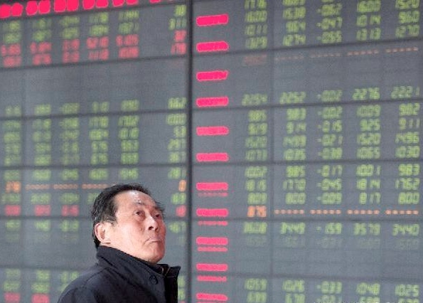 An investor looks through stock information at a trading hall of a securities firm in Hefei, capital of east China’s Anhui Province [Xinhua]