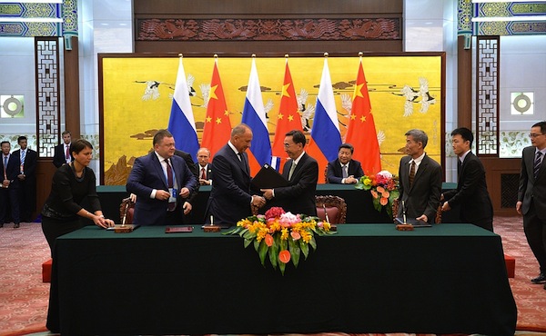 Russian President Vladimir Putin and his Chinese counterpart Xi Jinping (in the background) witness the signing of documents in beijing, China on 3 September 2015 [PPIO]