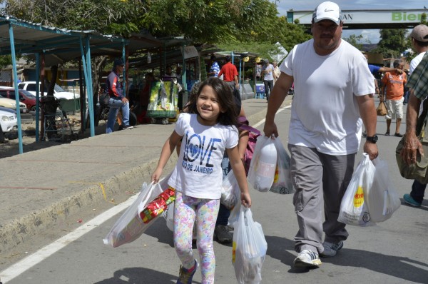Venezuelan citizens carry bags of food and other products they bought at a supermarket in Colombia after the crossings were opened on Sunday [Xinhua]