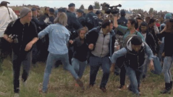 Petra Laszlo, seen her in a blue shirt and jeans, just as she kicks a young girl refugee as she escapes a police cordon on the Hungary-Serbia border in September 2015 [Screen grab]